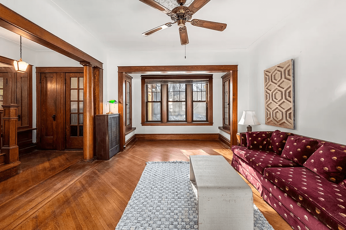 living room with wood floors, columns and original stair