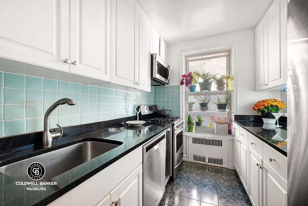 kitchen with white cabinets and blue wall tiles