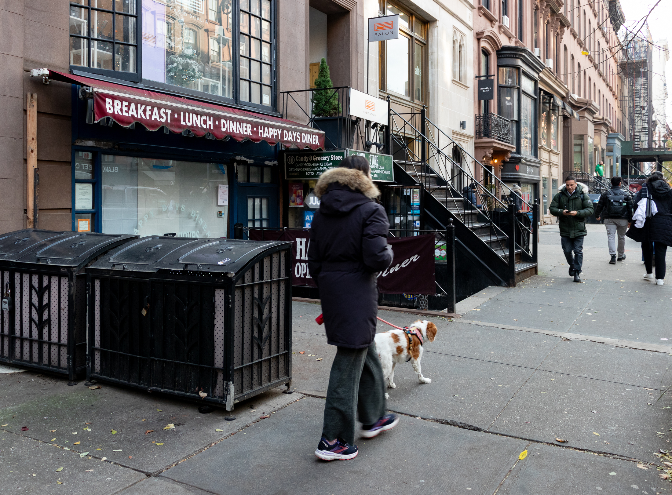 people walking on the sidewalk in front of the space