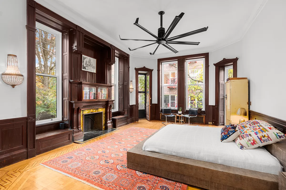 bedroom with wood mantel with windows on either side