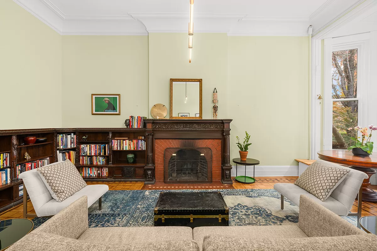 living room with wood mantel and bookshelves