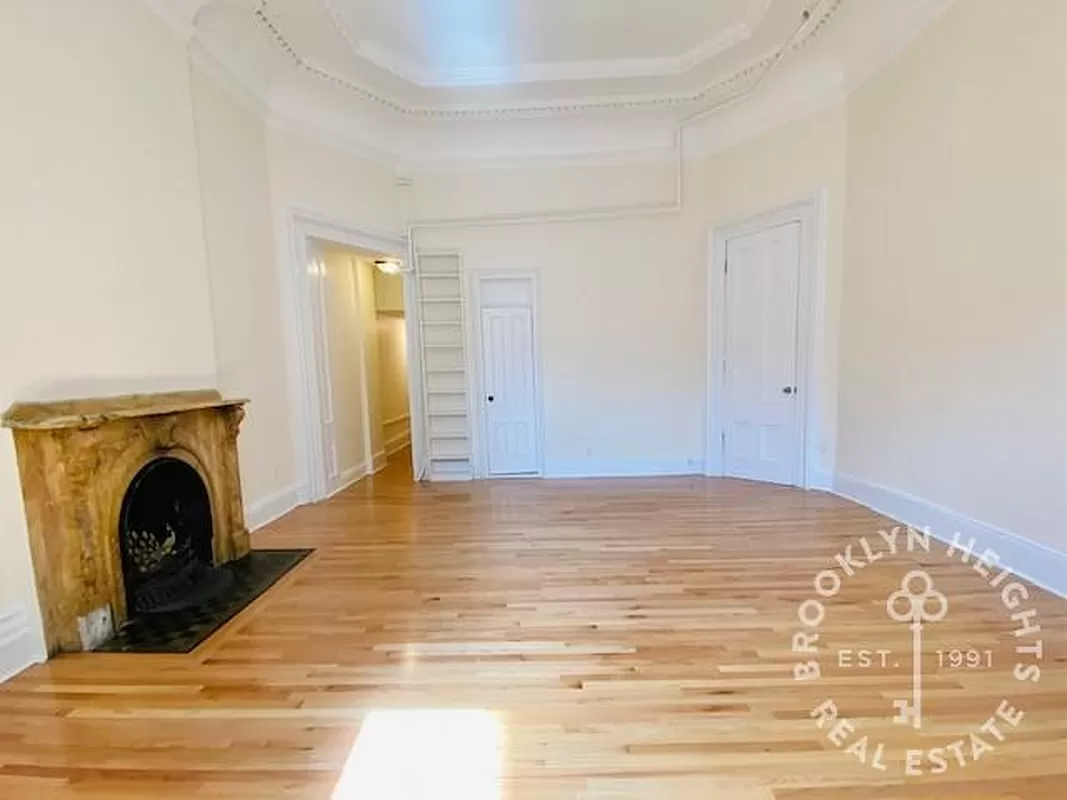 living room with mantel, high ceilings and plaster details