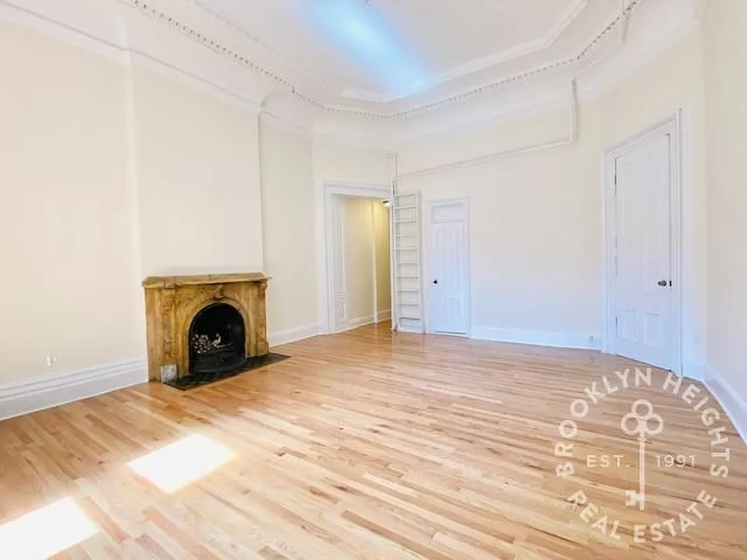 living room with mantel, high ceilings and plaster details