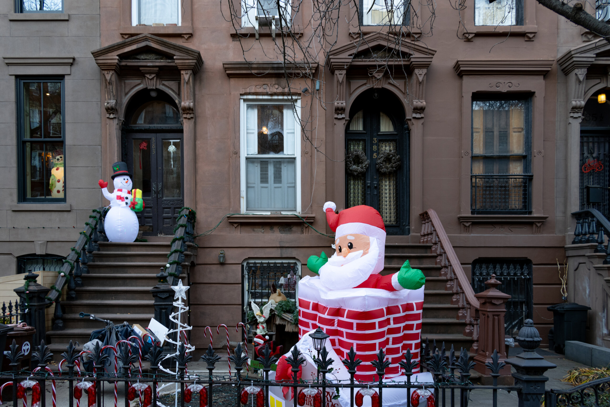 brooklyn - brownstone stoops with christmas decorations and a santa in the yard
