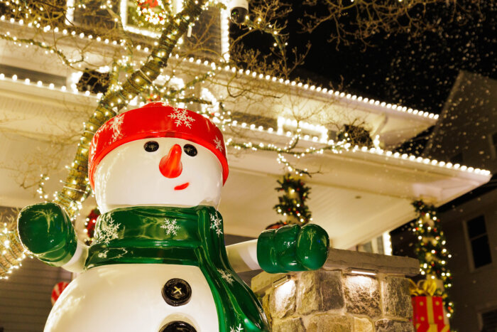 a large snowman outside a house