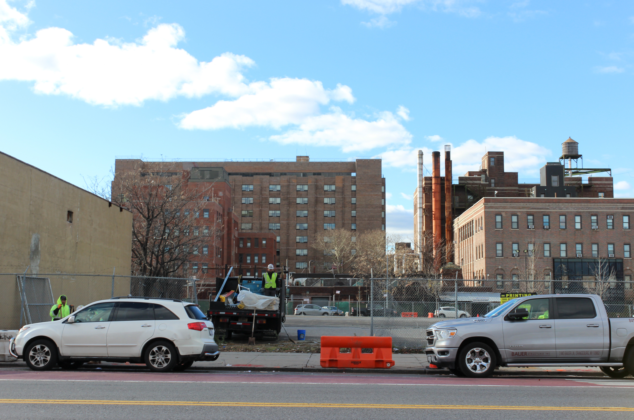 view across street to chain link fence around parking lot