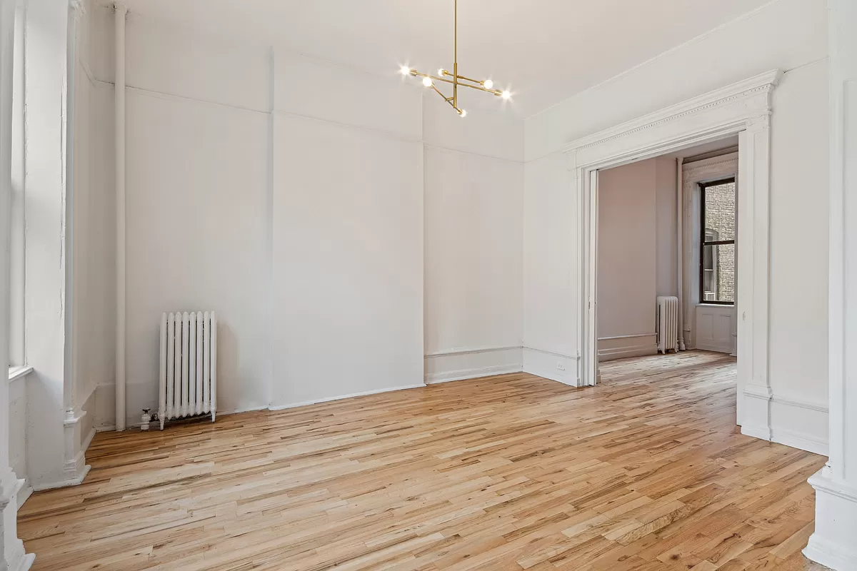 living room with picture rail and view into bedroom