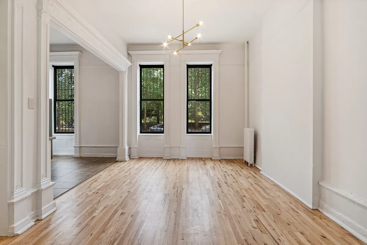 living room with tall windows and view into kitchen