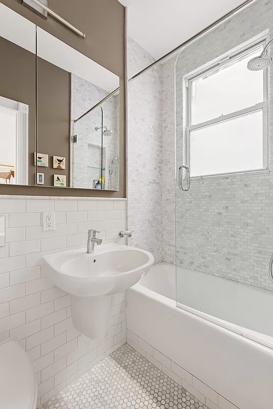 bathroom with white fixtures including a tub