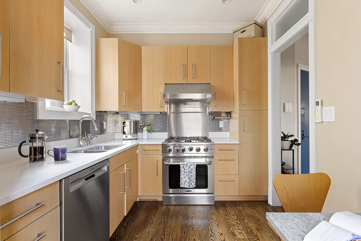 kitchen with pale wood cabinets and stainless steel appliances