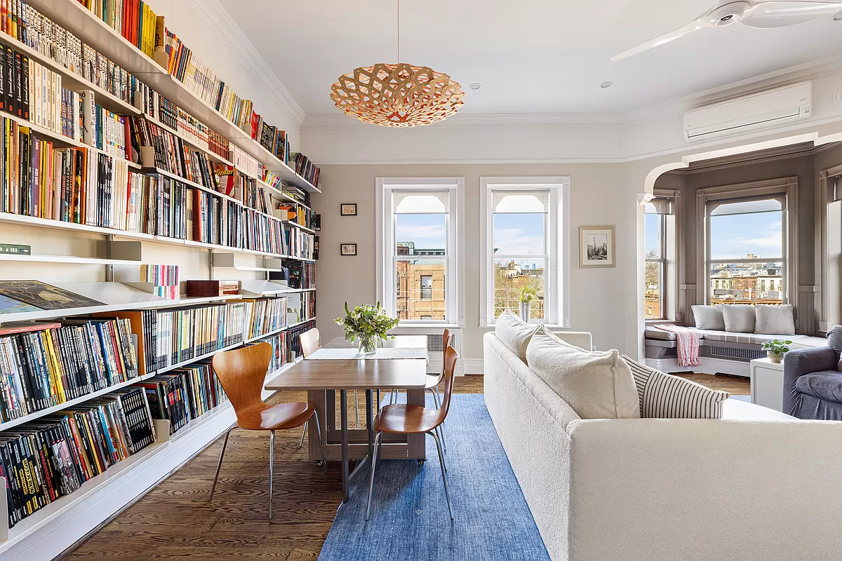 living room with wall of bookshelves and a window seat