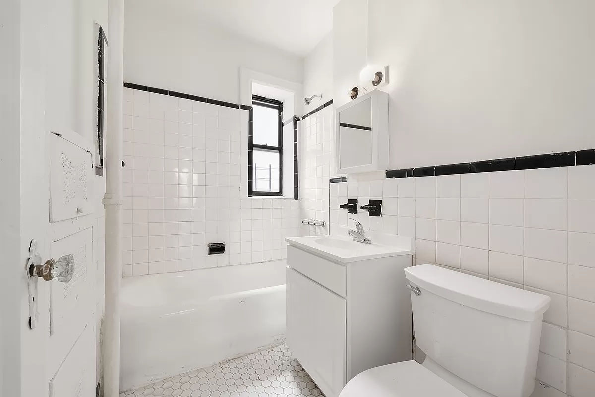 bathroom with white wall tile with black border tile