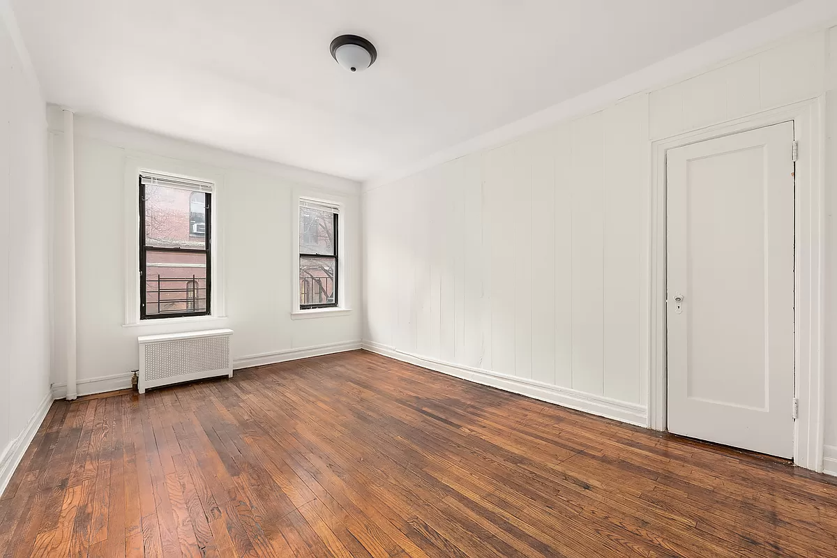 bedroom with wood floor and two windows