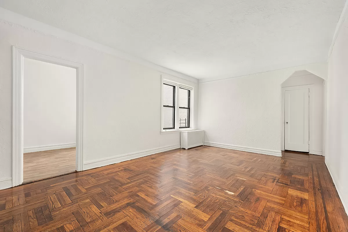 living room with wood floor and arched opening to foyer