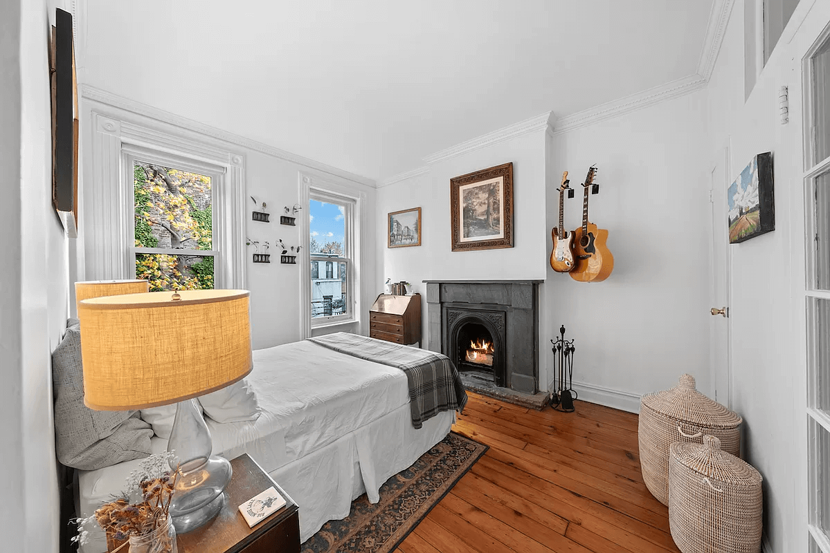 bedroom with mantel and wood floor