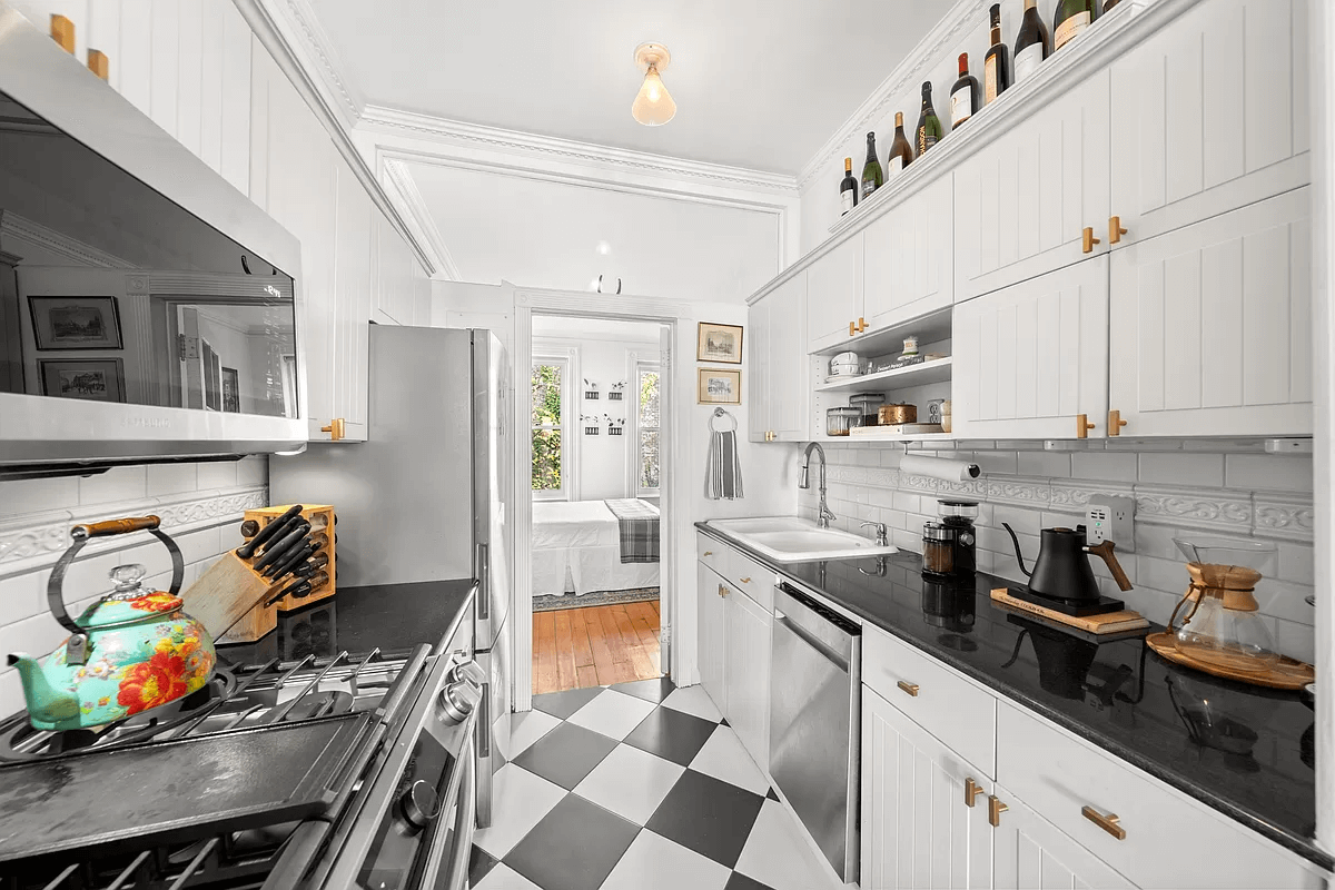 kitchen with black and white floor tile and white cabinets