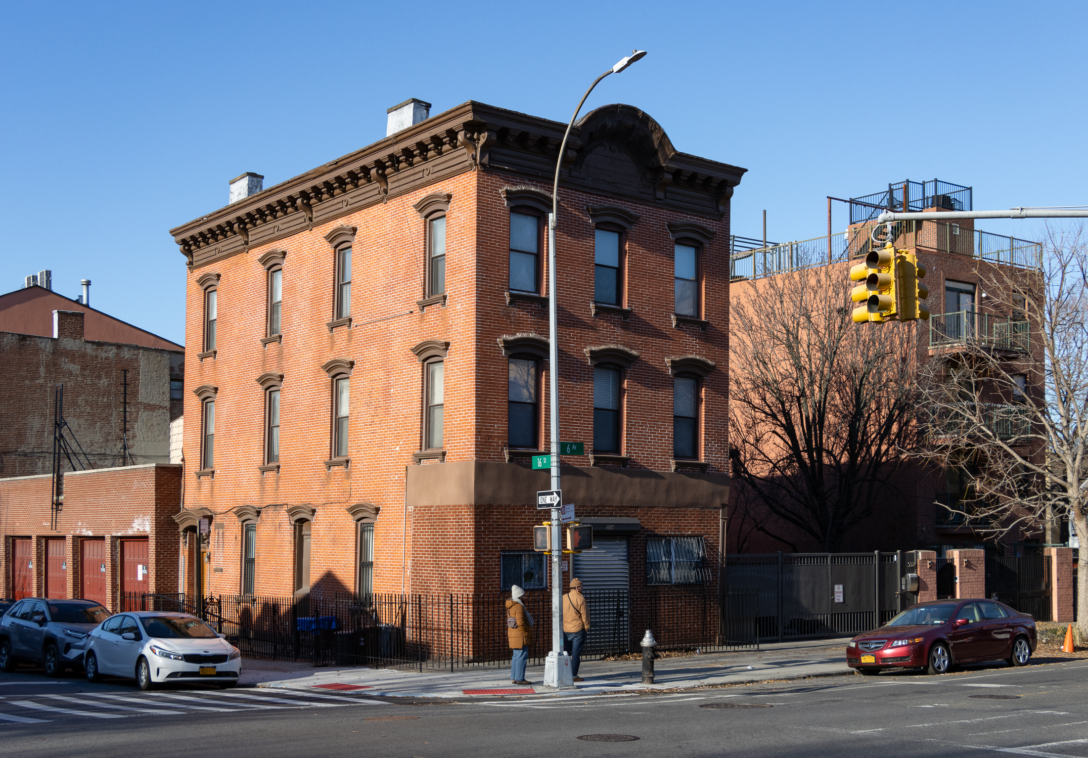 brooklyn - people in winter coats standing in front of a 19th century brick building on 6th avenue