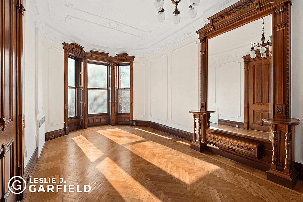 parlor with wood floor, moldings and mirror