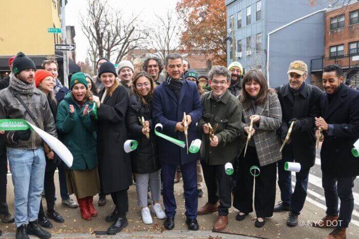 officials cutting a green ribbon