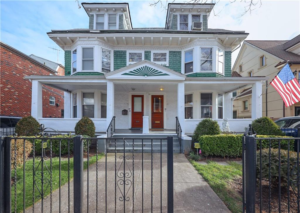 exterior of semidetached house with porch and green shingles