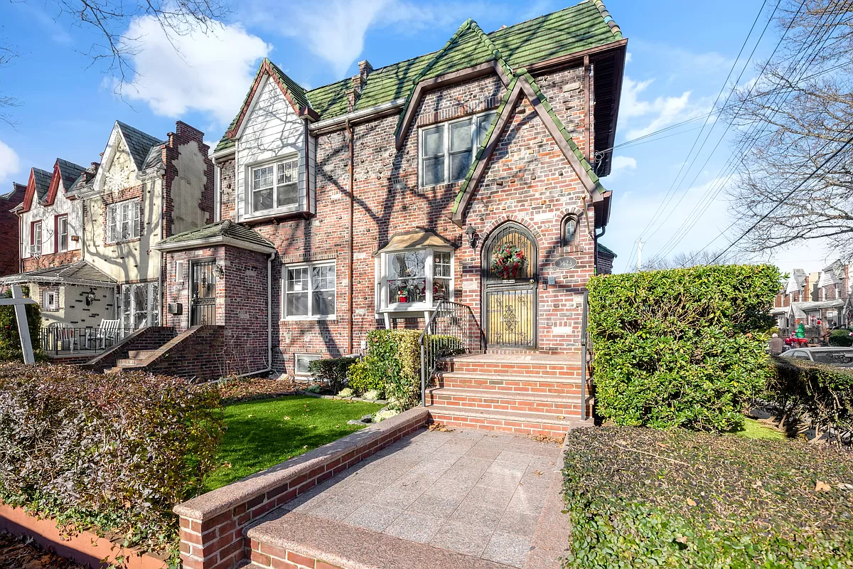 tudor style brick house with green shingles