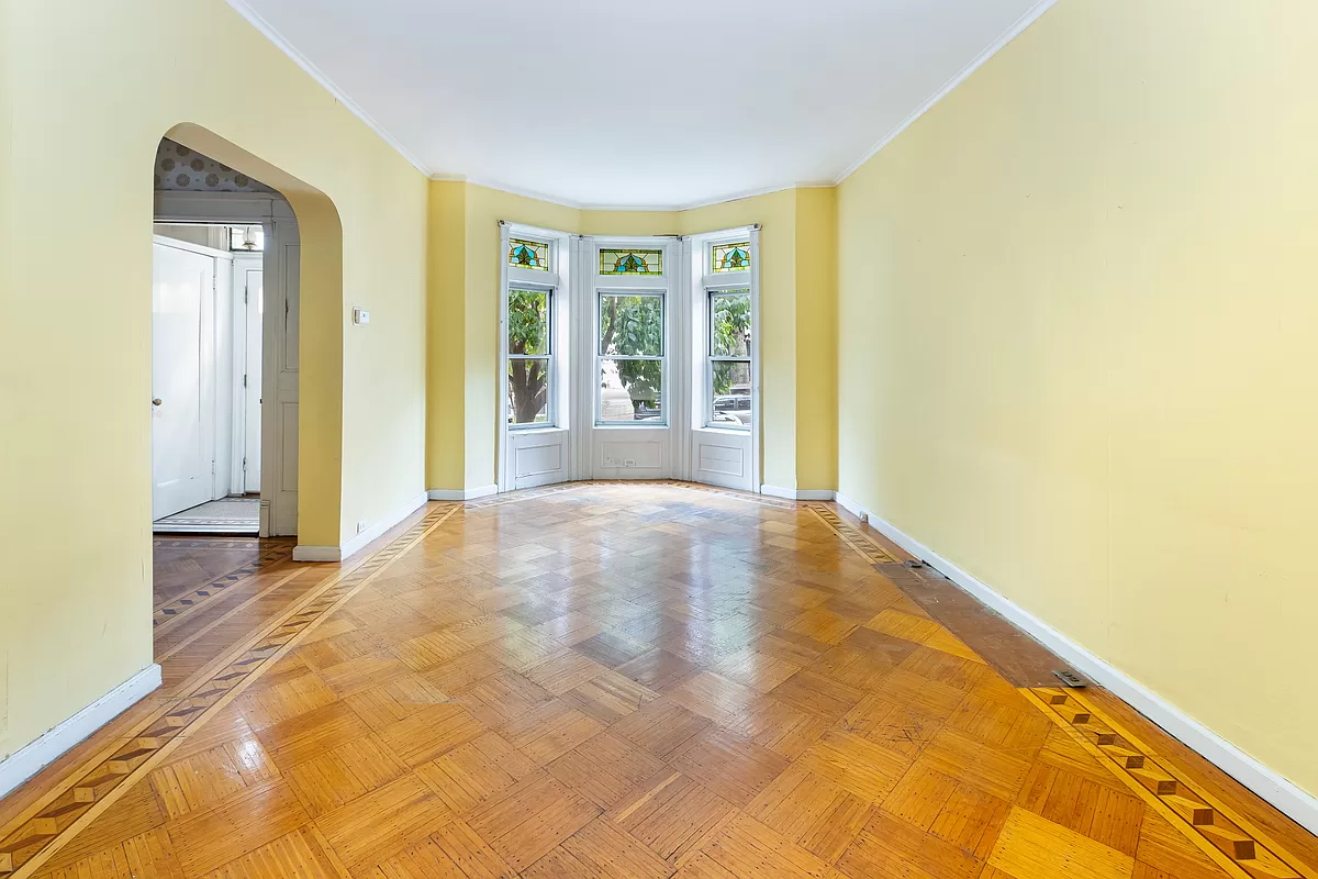 living room with wood floor, arched opening to foyer