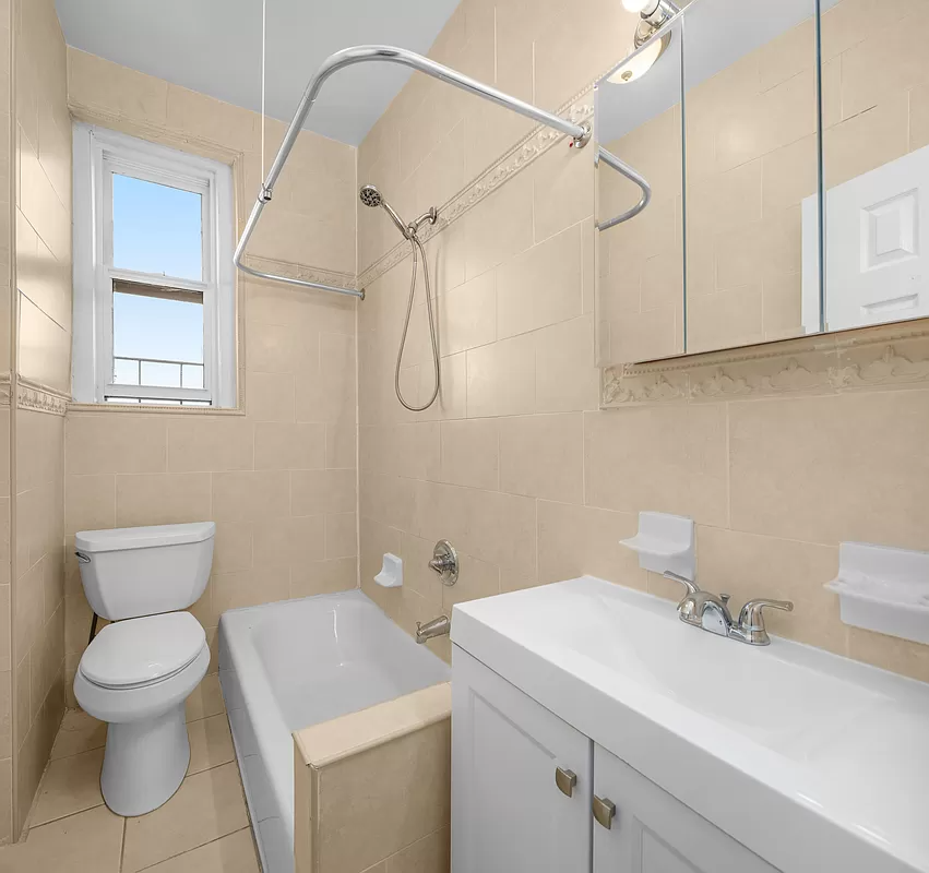 bathroom with white fixtures and beige tile