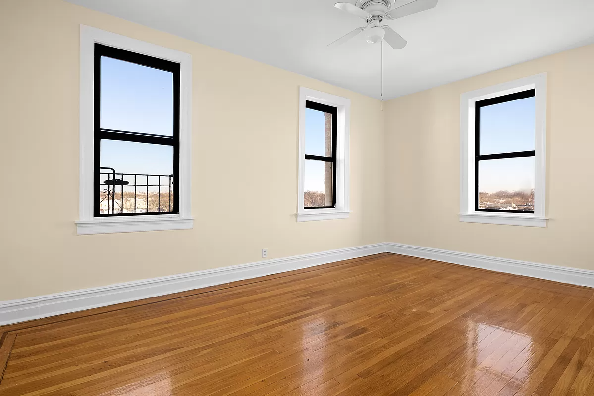 bedroom with two exposures, a ceiling fan and wood floor