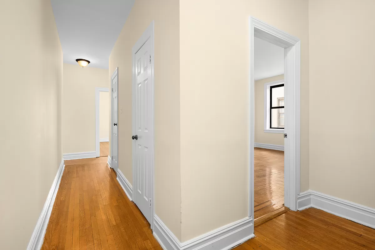 hall with wood floors and two closets