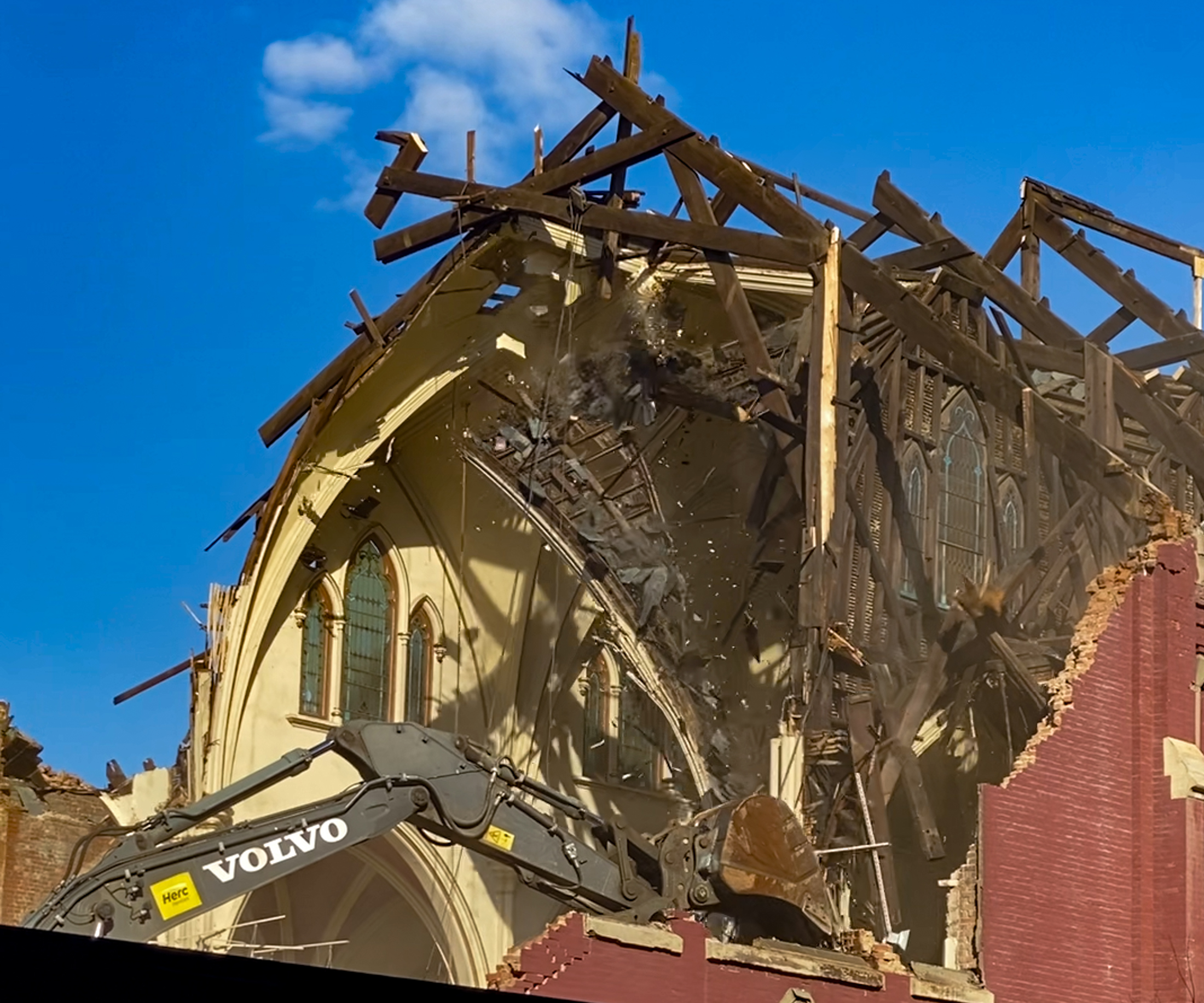 excavator demolishing the roof of a church