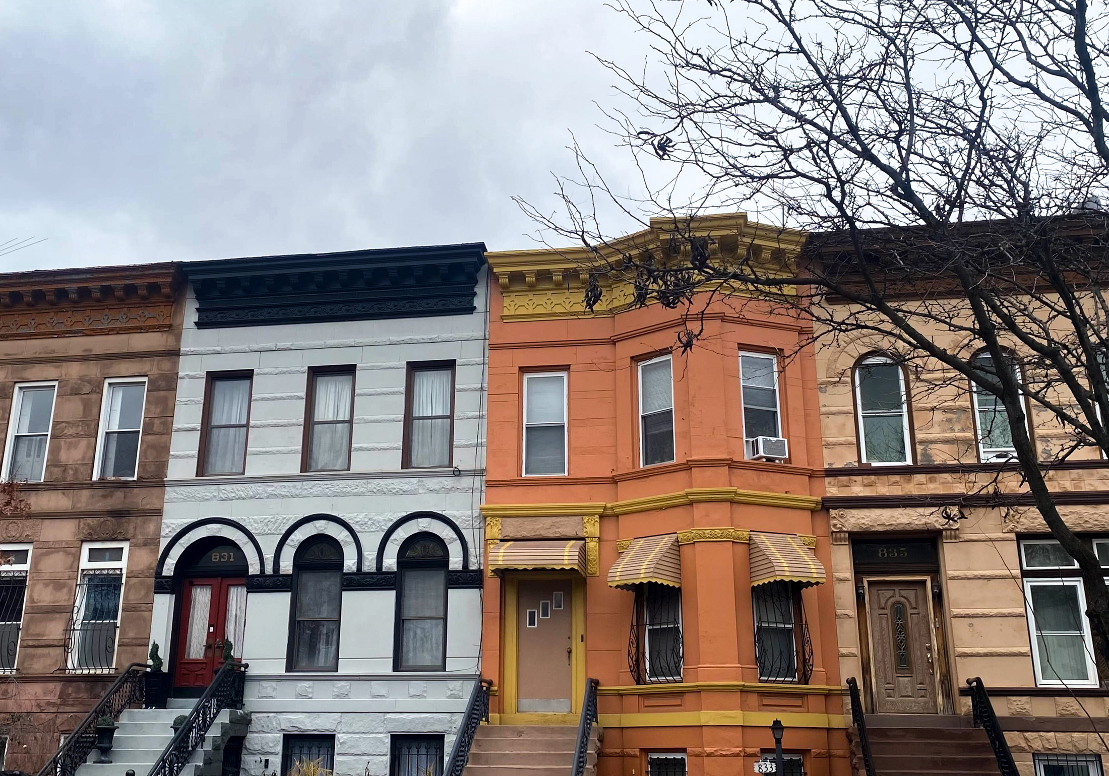 brooklyn - an orange rowhouse in a row of painted houses