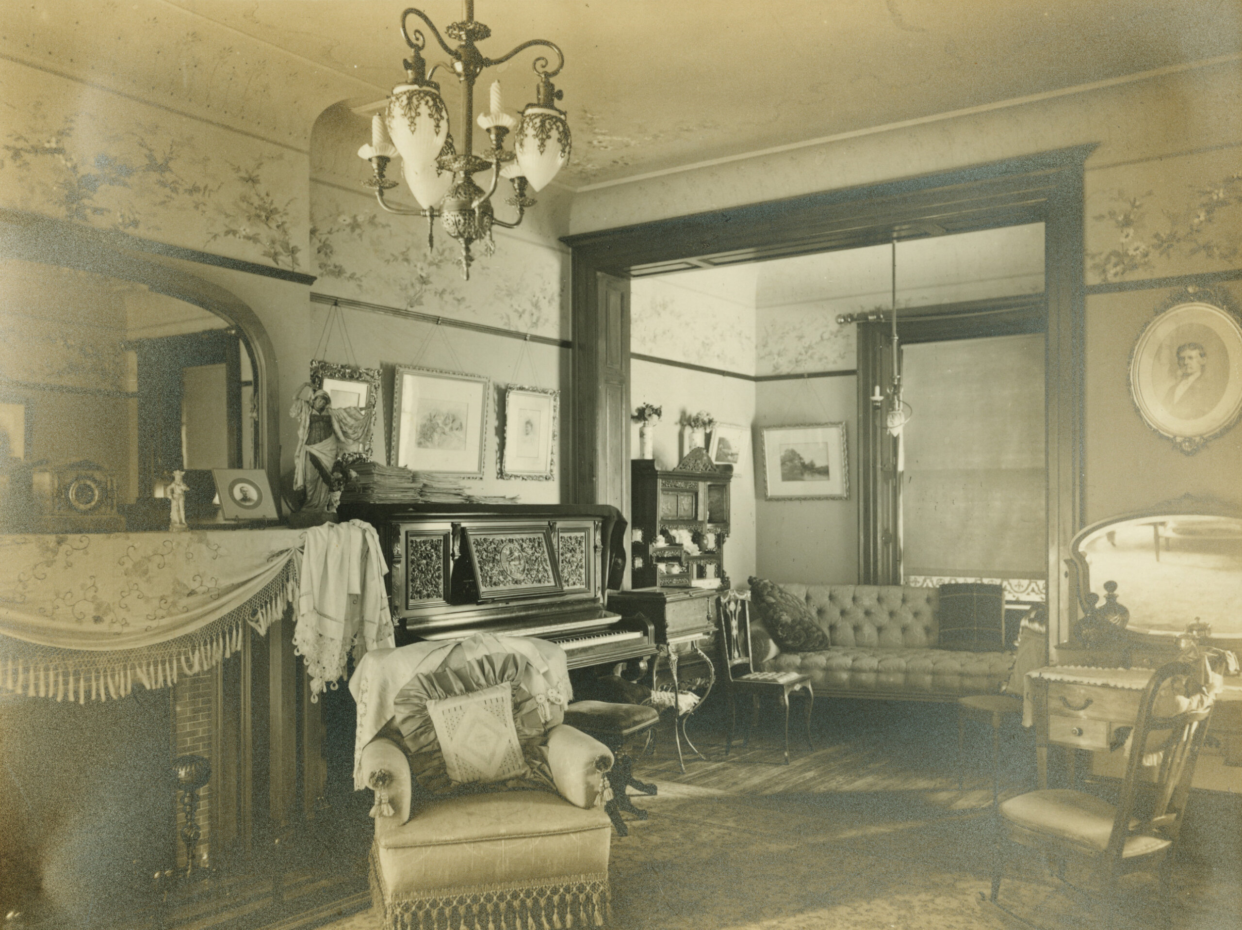 parlor with fabric draped over the mantel next to a piano