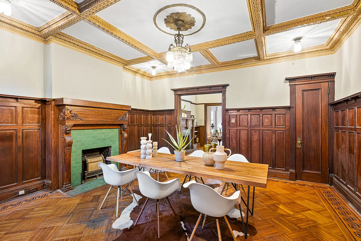 dining room with wainscoting and a wood mantel with green tile