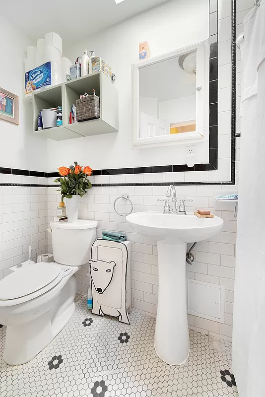 bathroom with black and white tile and white fixtures
