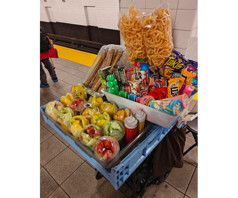 a cart loaded with fruit, candy and other food for sale