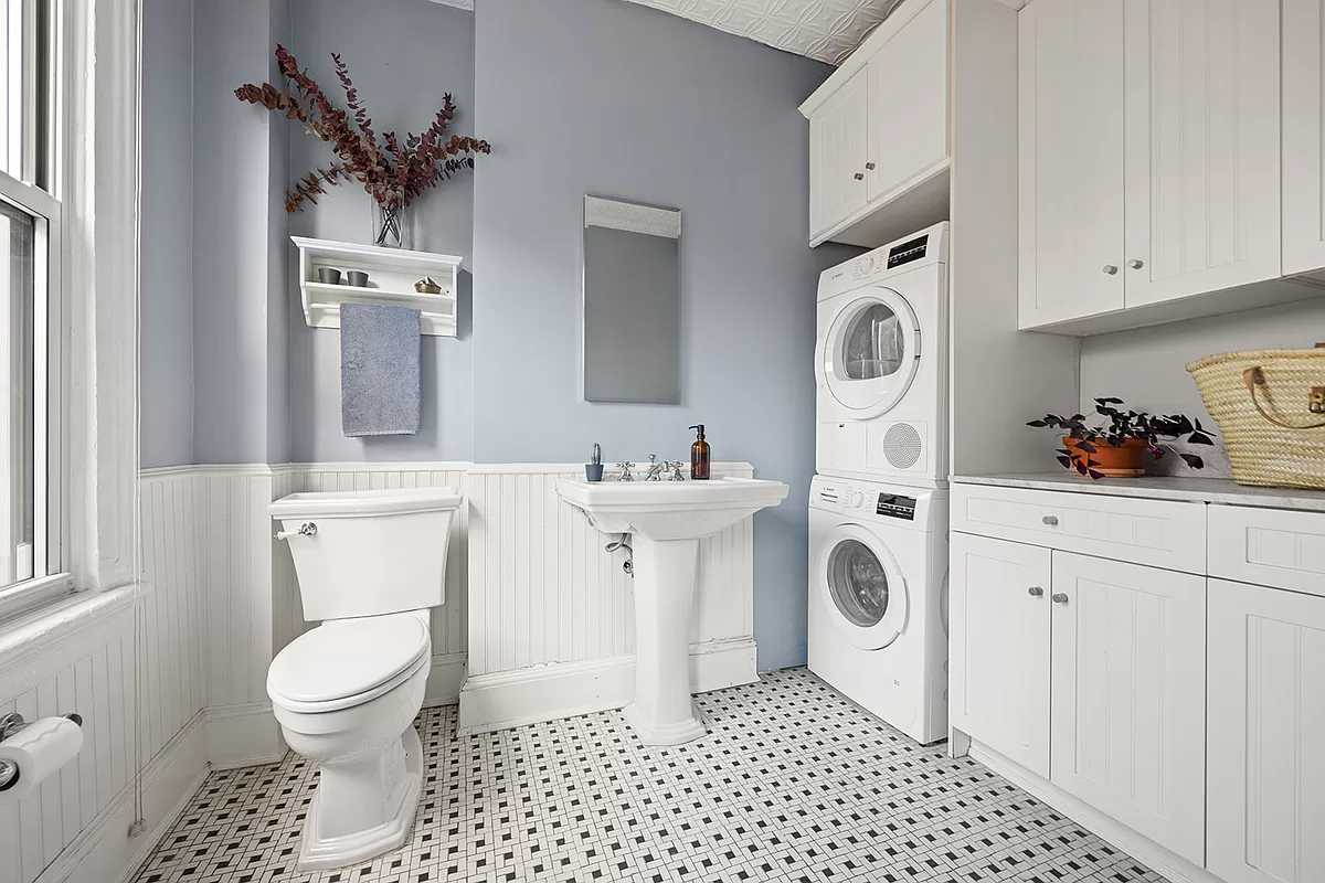 bathroom with white fixtures and stackable laundry