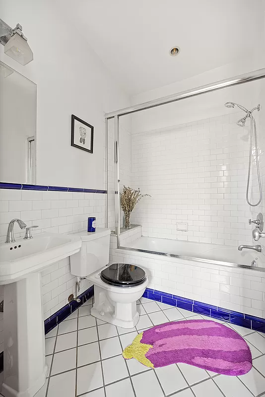 bathroom with white fixtures and blue accent tiles