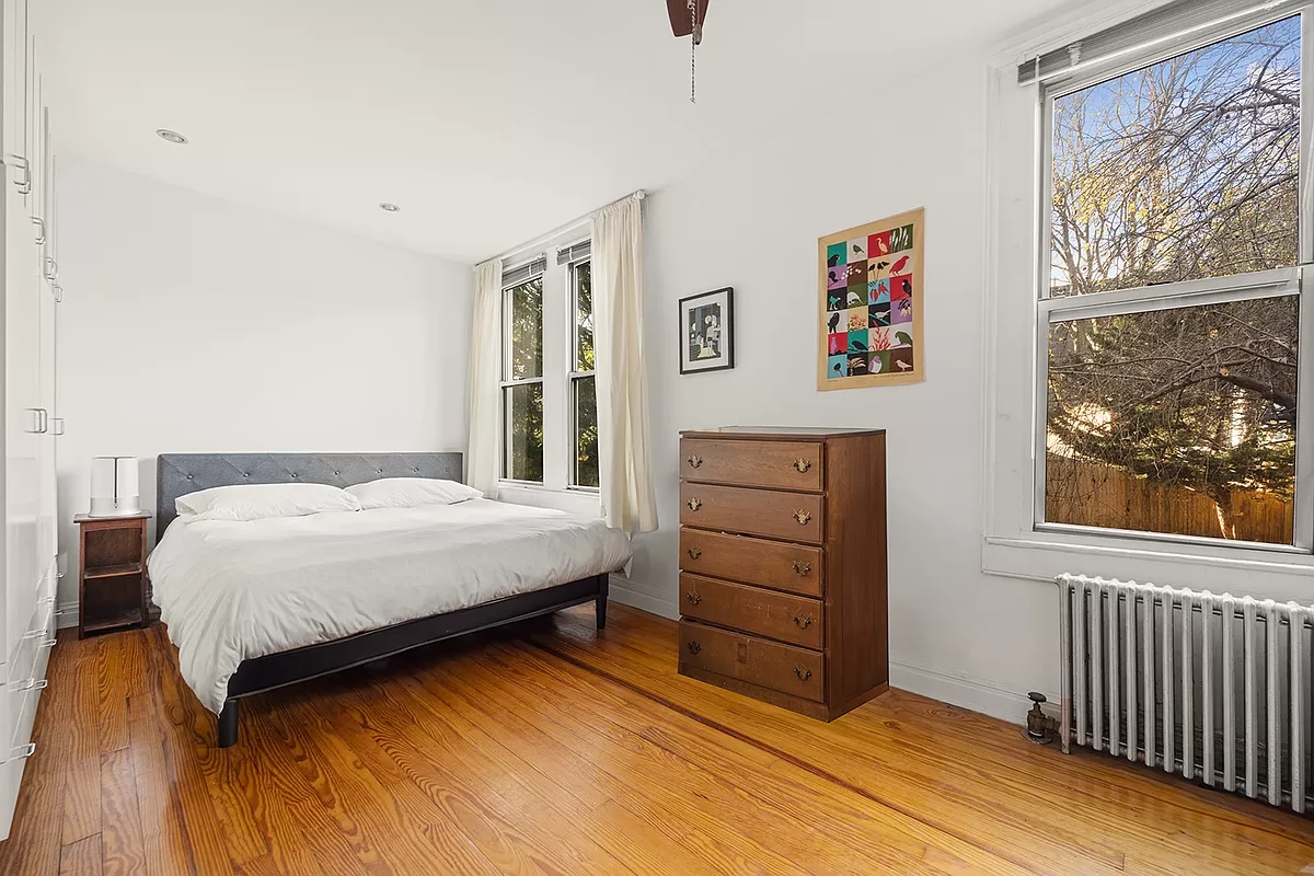 bedroom with wood floor and two windows