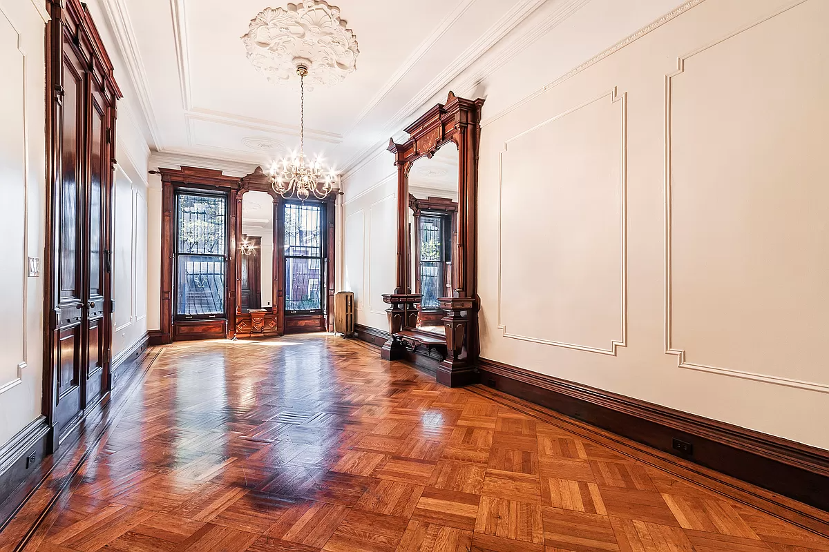 brooklyn parlor with wall moldings, a pier mirror and wood floor