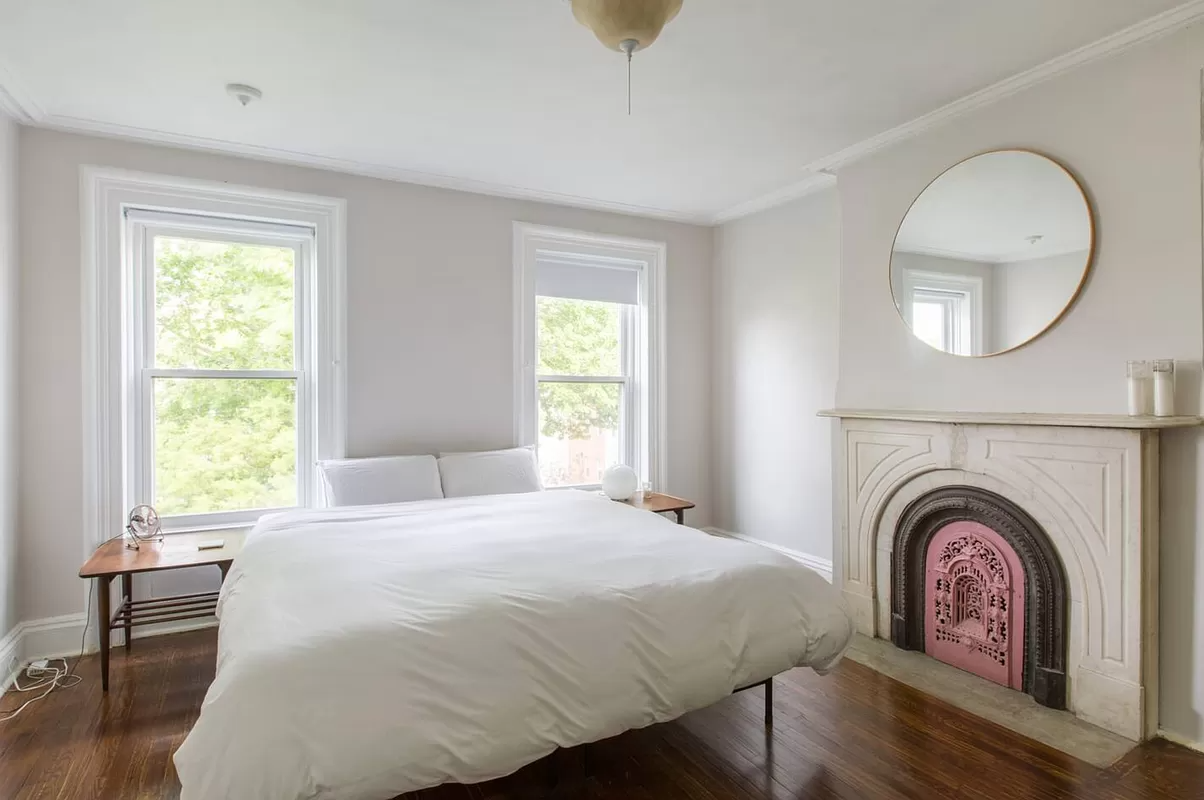 bedroom with two windows and a marble mantel