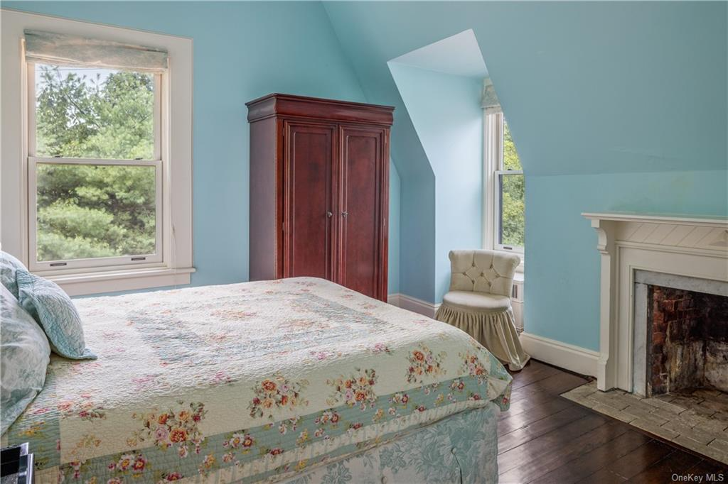 bedroom with mantel, two exposures and blue walls