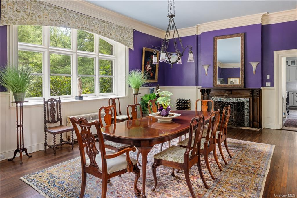 dining room with wood floor, wood mantel and wainscoting