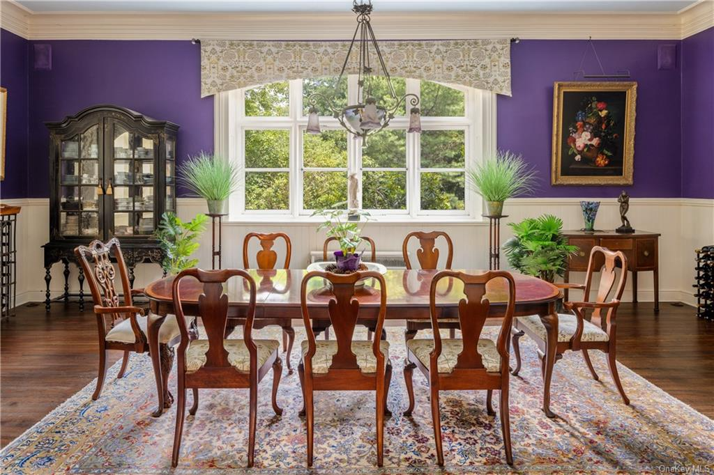 dining room with wainscoting and purple walls above