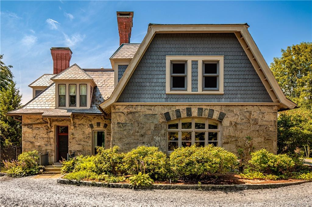 view of the side of the house with stone lower level and shingled upper