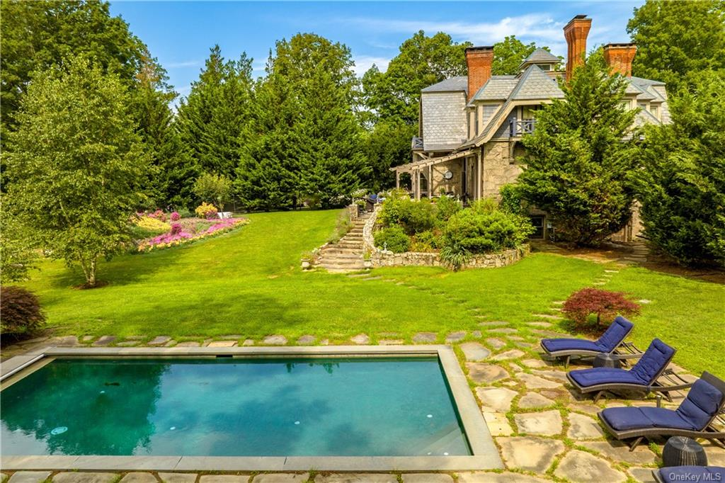 pool adjacent to house with stone path