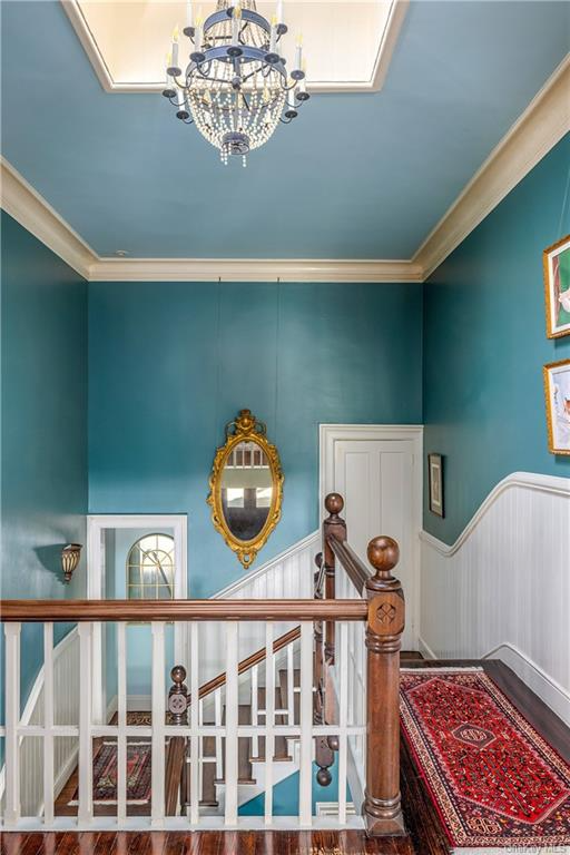 upper stair hall with blue walls and beadboard