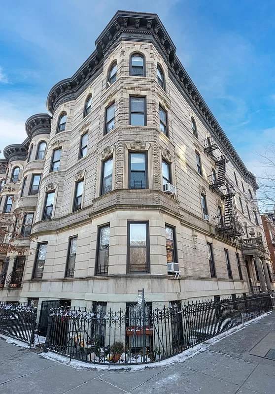 pale stone exterior of the buildning with a dark, bracketed cornice