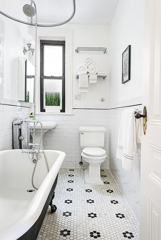 bathroom with claw foot tub and black and white floor tile