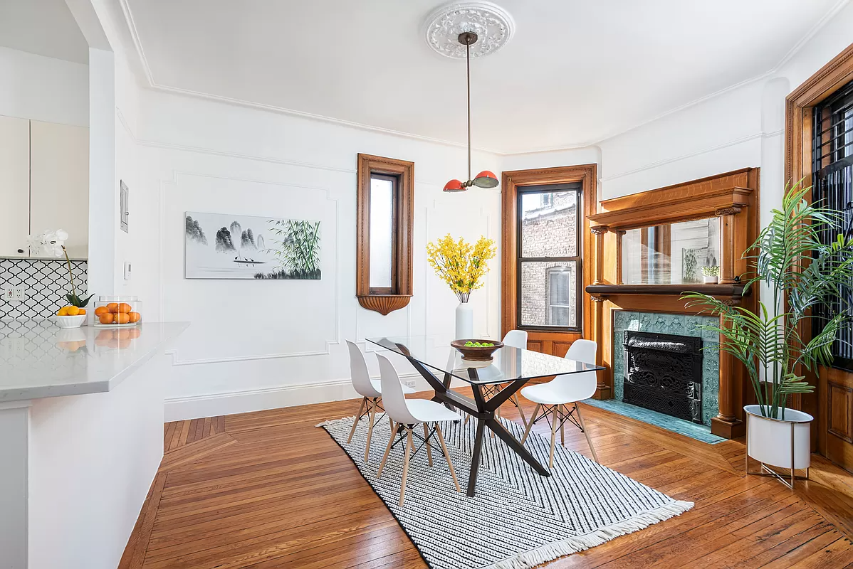 dining area with a wood mantel and separated from kitchen by a peninsula