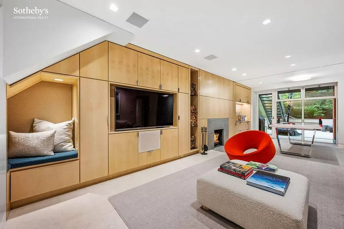 lower level den with fireplace and wall of built-ins with a reading nook